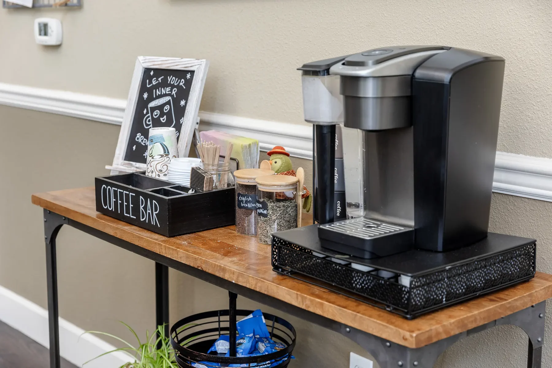 Coffee bar with automatic coffee machine and various tea and coffee options.