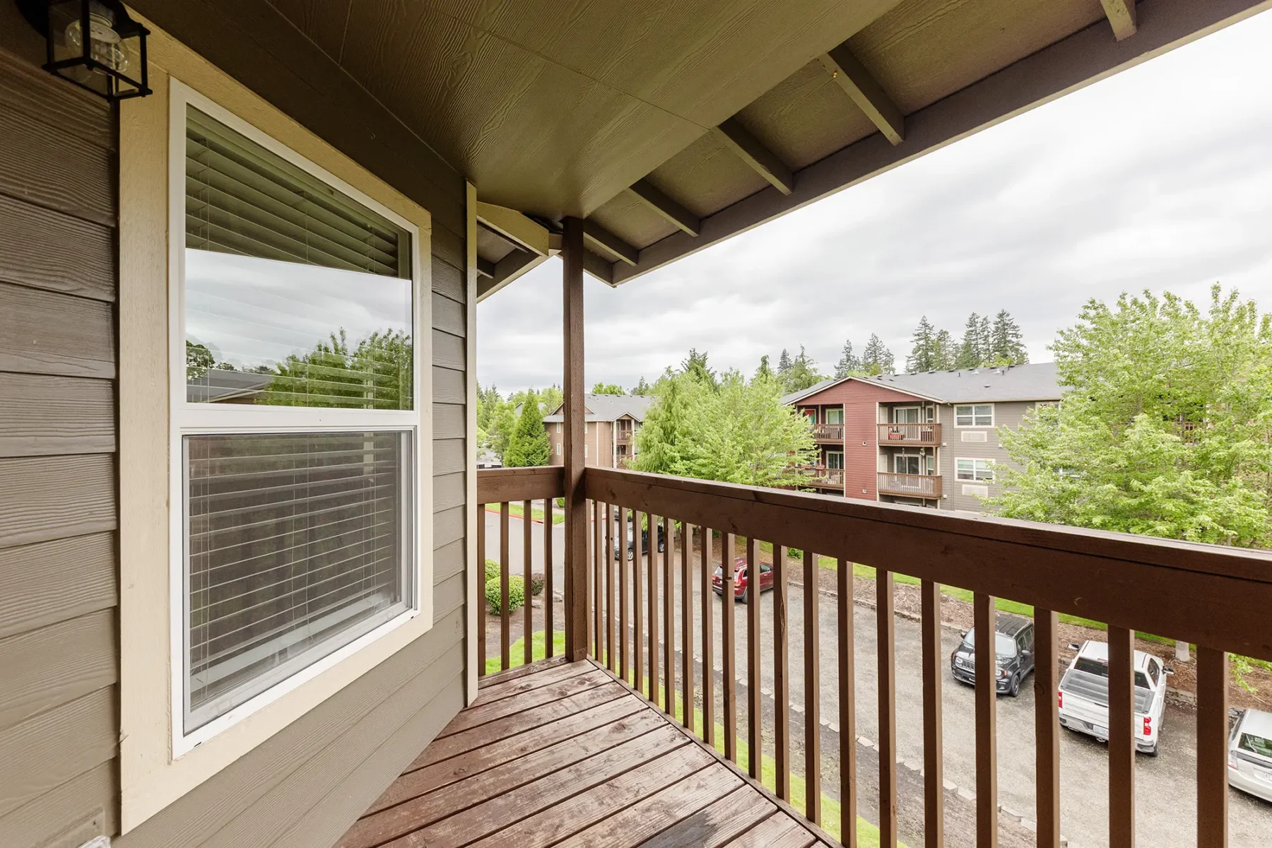 Private covered balcony with view of exterior apartment units.